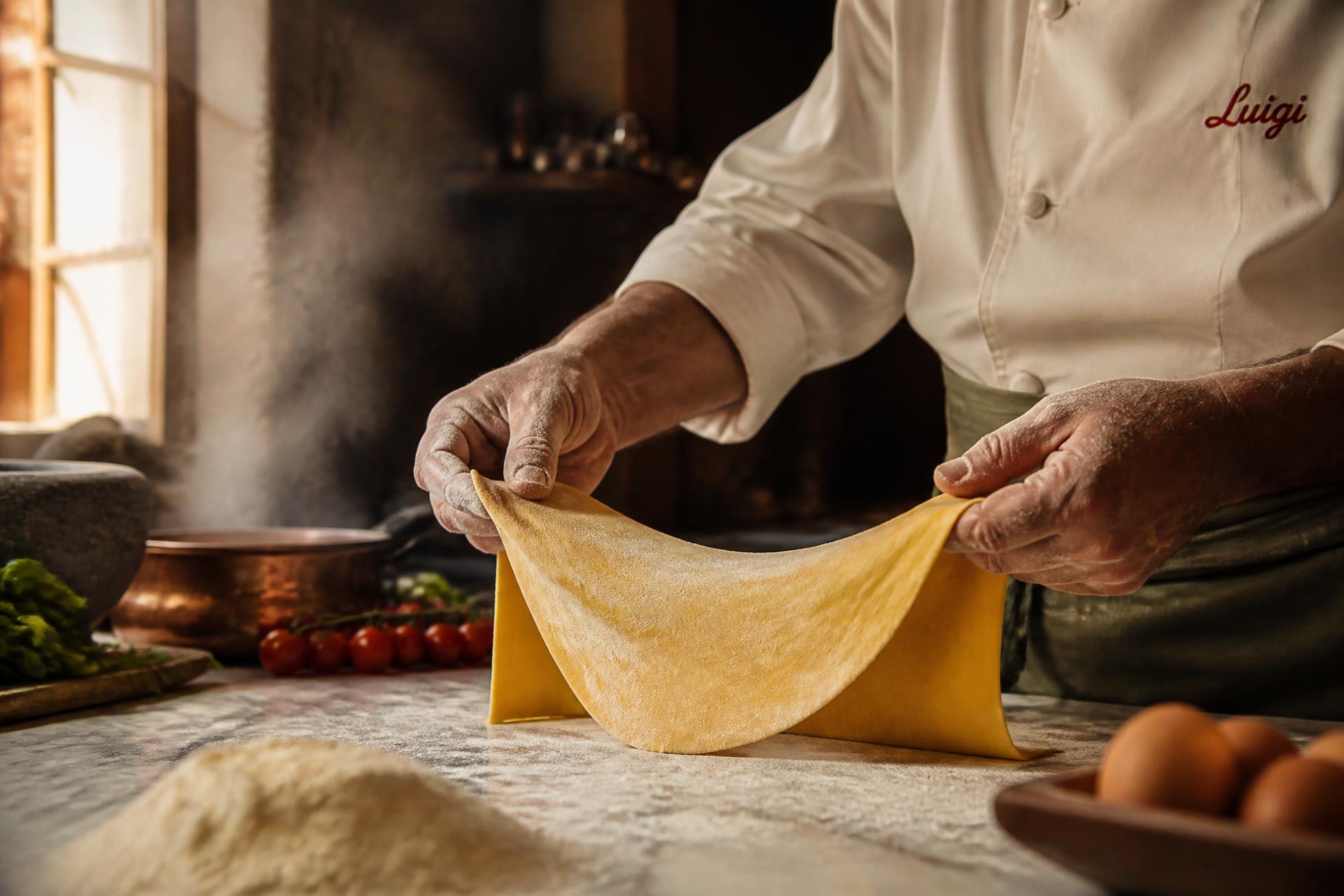 Hands stretching fresh pasta dough in the Sapore Express kitchen